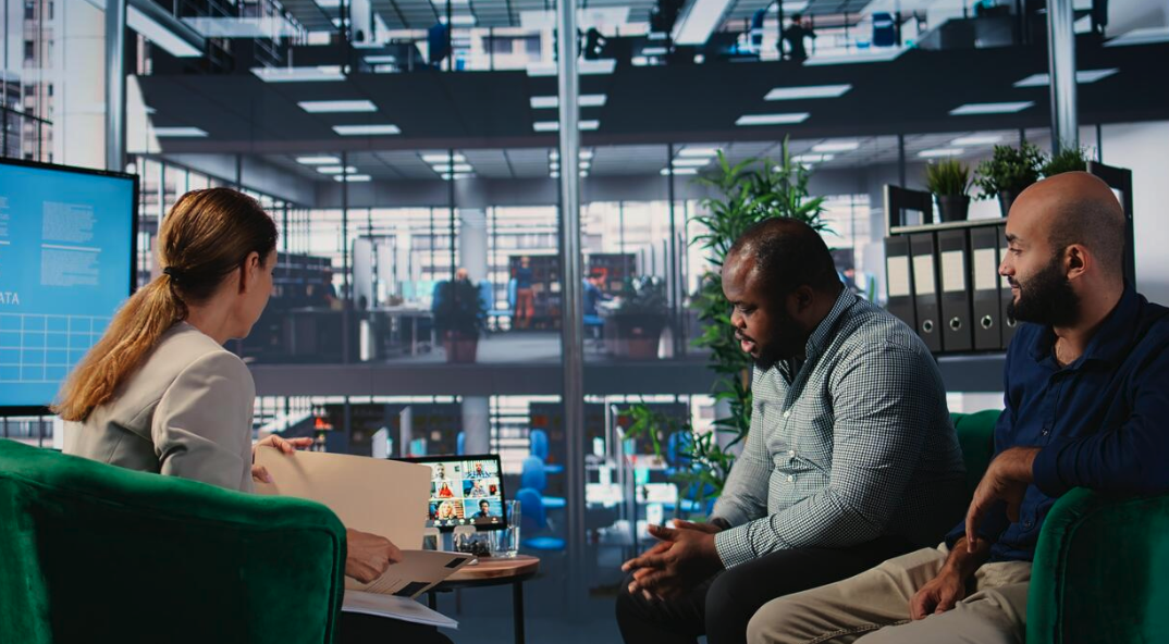 A diverse interview panel meeting a candidate in person